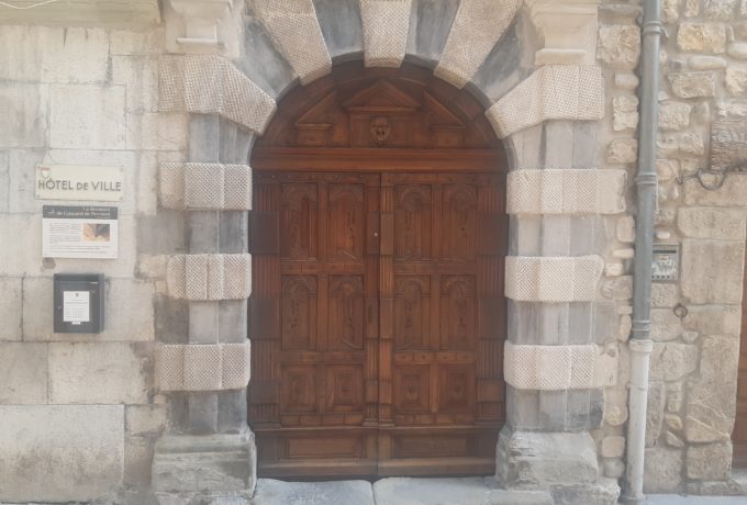 Photo en couleur de l'imposante porte en bois de la mairie de Serres.